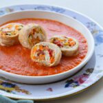 Foto di un piatto di Involtini di Tacchino a fette ripieni di ortaggi su salsa di peperoni
