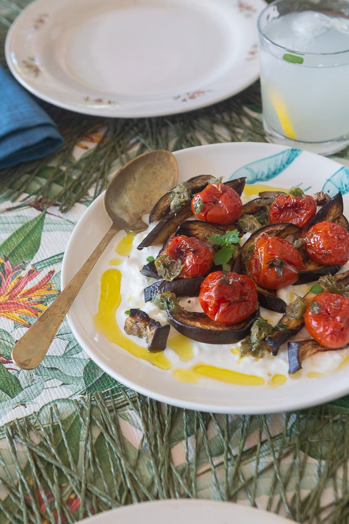 Piatto di Melanzane e pomodorini arrostiti con stracciatella sulla tavola